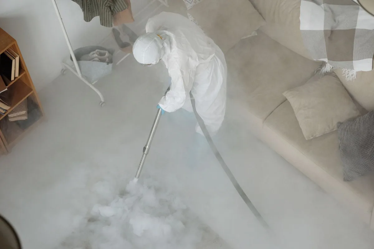 Biohazard cleanup technician in protective equipment, Barton, NM